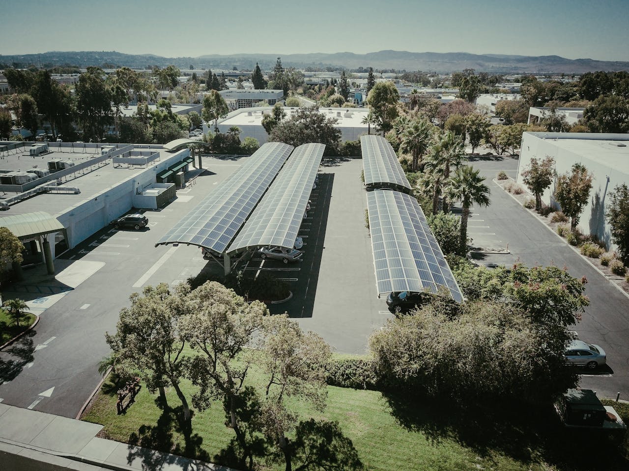 Aerial shot of solar panel installations in a suburban neighborhood under clear skies.